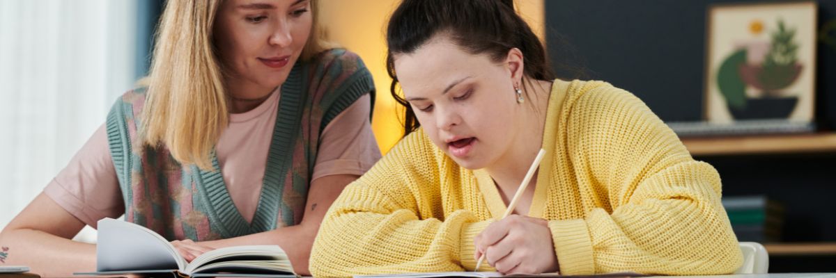 NDIS Participant is helped by her support worker to fill out paperwork.