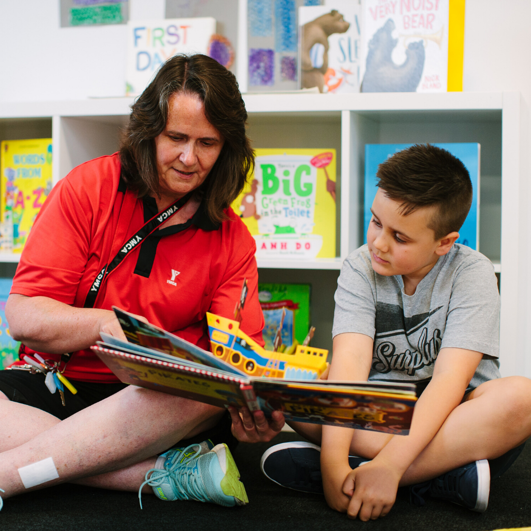 YMCA staff member reading a picture book to a child