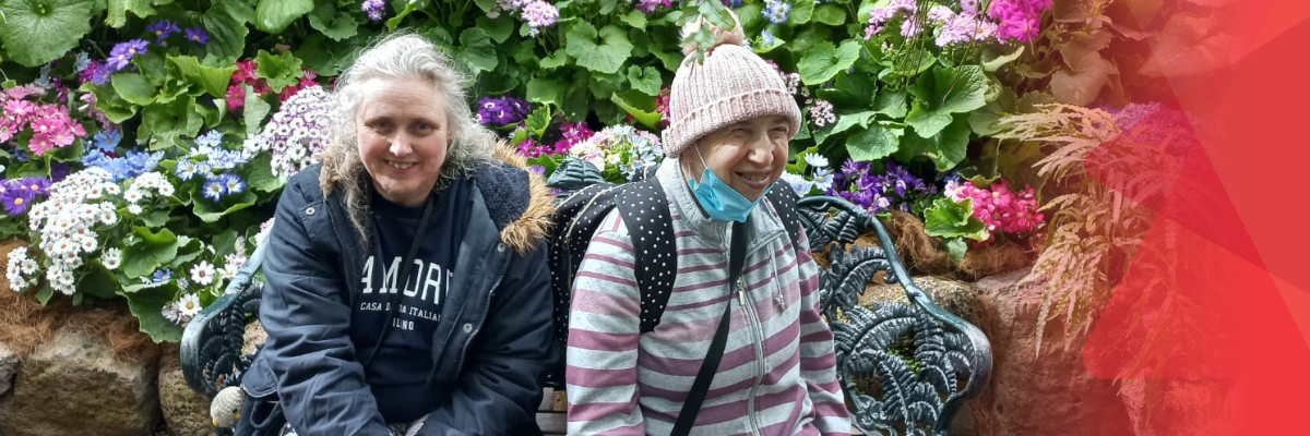 2 women smiling in a lush garden