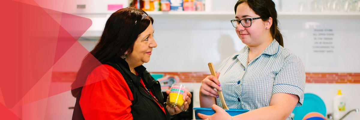 A cook teaching her Y enterprise participant in the kitchen.